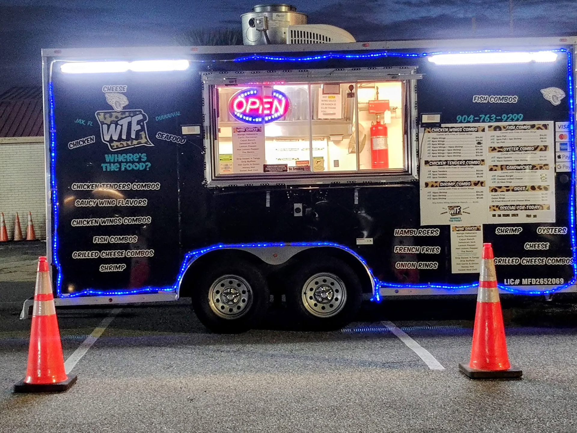 WTF food truck — black trailer with leopard print and bright teal lights